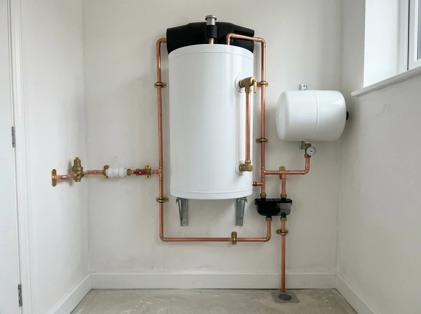 White unvented hot water cylinder with neatly clipped copper pipework and safety valves